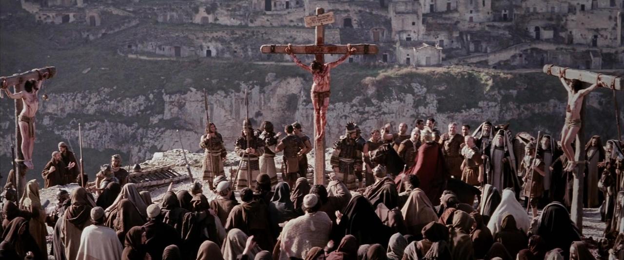 Кадр фильма Страсти Христовы - 3 креста на возвышенности, вокруг крестов толпа людей